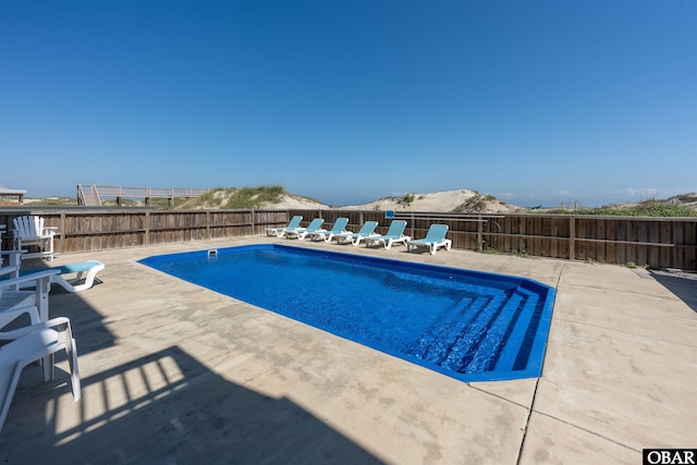 view of pool featuring a patio, a fenced backyard, a mountain view, and a fenced in pool