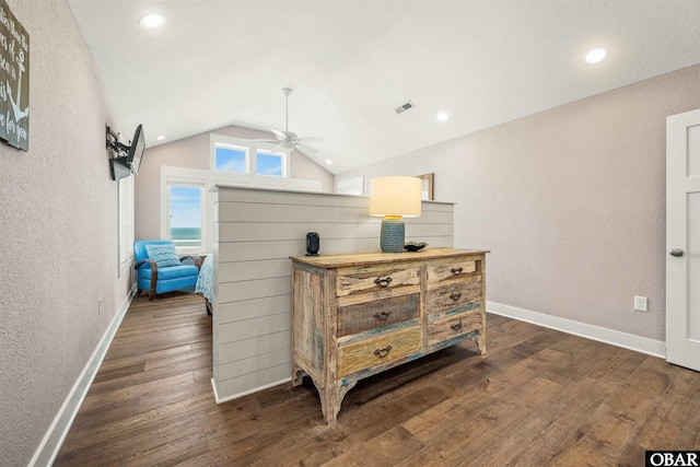 interior space with a textured wall, dark wood finished floors, vaulted ceiling, and baseboards