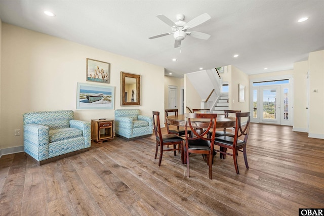 dining room featuring stairs, ceiling fan, wood finished floors, and baseboards