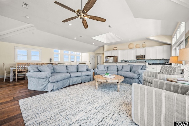 living area with recessed lighting, visible vents, lofted ceiling with skylight, a ceiling fan, and wood finished floors