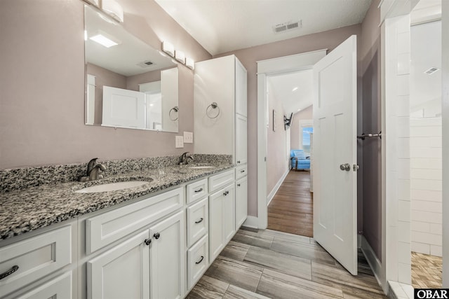 bathroom featuring double vanity, baseboards, visible vents, and a sink