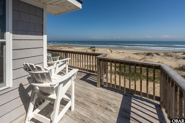 wooden deck with a beach view and a water view