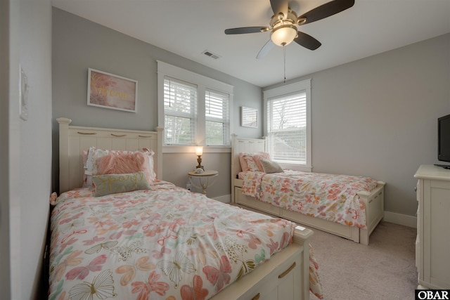 bedroom with visible vents, light carpet, baseboards, and a ceiling fan