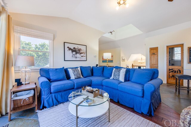 living room featuring lofted ceiling and a notable chandelier