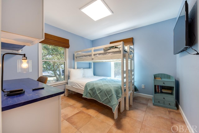 bedroom with light tile patterned floors and baseboards