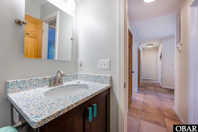 bathroom featuring tile patterned flooring, vanity, and baseboards