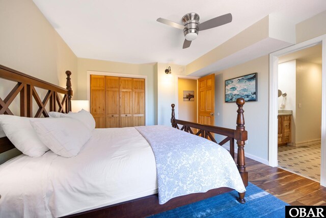 bedroom featuring ceiling fan, a closet, baseboards, and wood finished floors