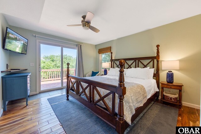 bedroom with baseboards, wood finished floors, a ceiling fan, and access to exterior