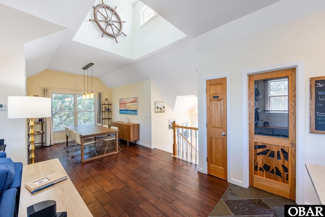 interior space featuring dark wood-type flooring, lofted ceiling, and baseboards