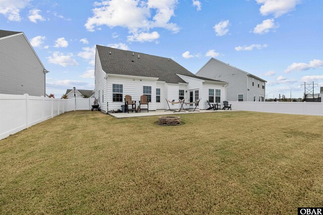 back of property featuring an outdoor fire pit, a lawn, a patio area, and a fenced backyard