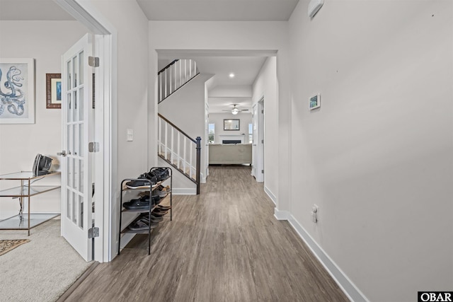 hallway with french doors, stairway, baseboards, and wood finished floors