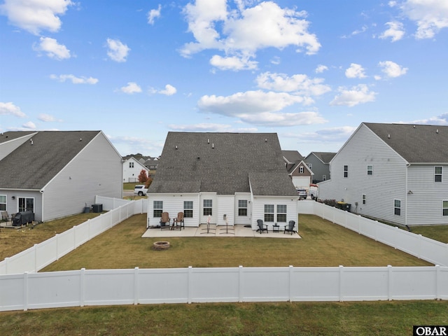 view of front of property with roof with shingles, an outdoor fire pit, a patio area, a fenced backyard, and a front lawn