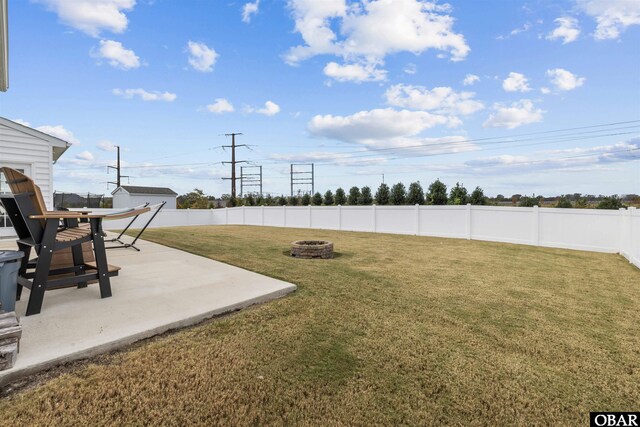 view of yard with a fenced backyard, a patio, and a fire pit