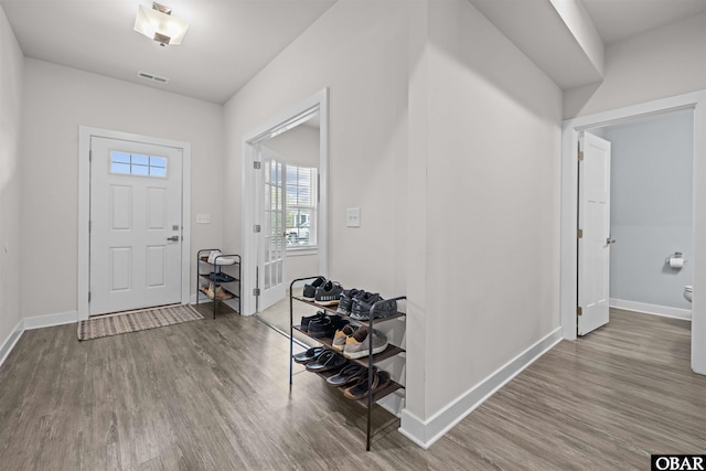 foyer entrance with wood finished floors, visible vents, and baseboards