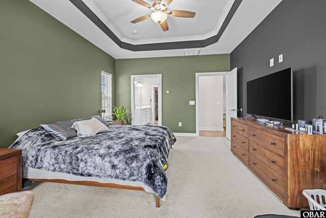 bedroom featuring baseboards, visible vents, a raised ceiling, light colored carpet, and ceiling fan