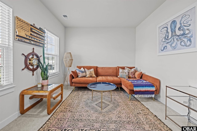 living area with carpet floors, visible vents, and baseboards