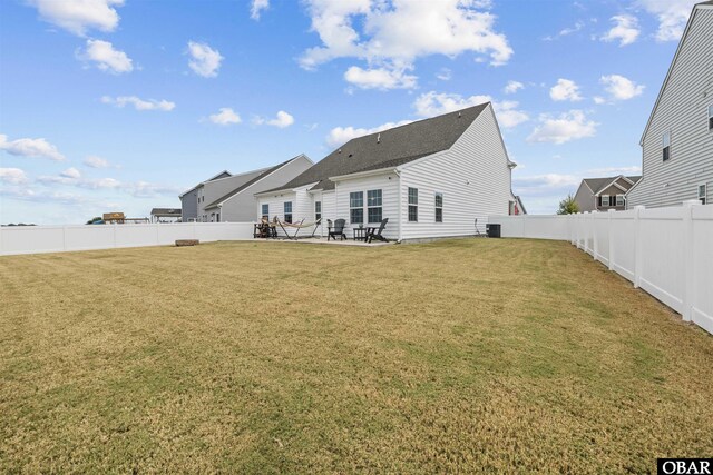 back of property with central air condition unit, a fenced backyard, a patio, and a yard