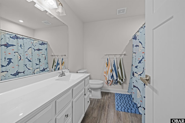 full bath with toilet, wood finished floors, visible vents, vanity, and baseboards