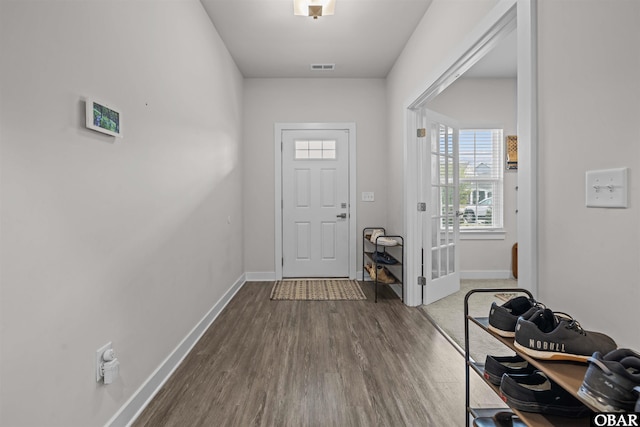 foyer featuring wood finished floors, visible vents, and baseboards