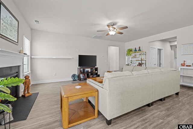 living room featuring a fireplace, wood finished floors, and visible vents