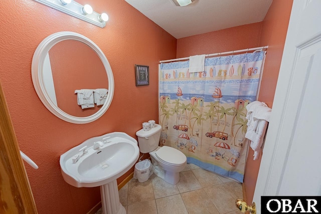 full bathroom with tile patterned floors, curtained shower, toilet, and a textured wall
