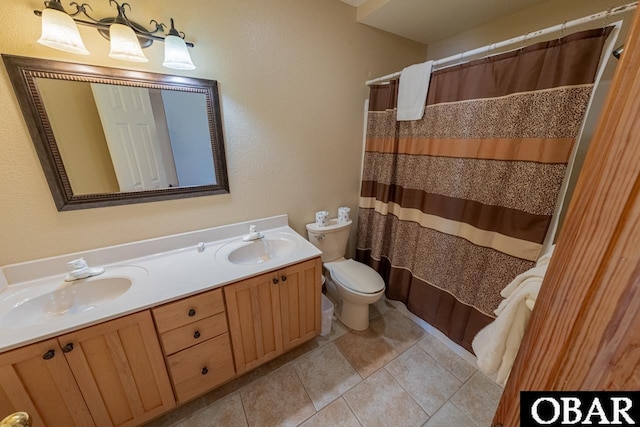 bathroom featuring double vanity, toilet, tile patterned floors, and a sink
