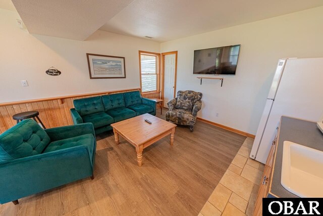 living area with visible vents, a wainscoted wall, and light wood-style flooring