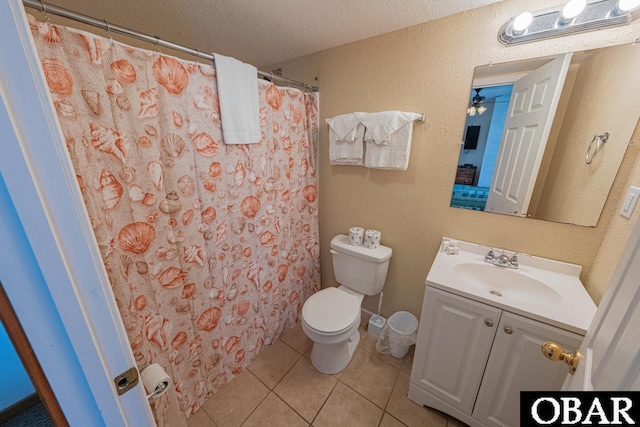 bathroom with tile patterned flooring, toilet, a textured wall, vanity, and a textured ceiling
