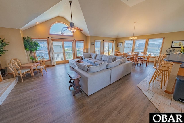 living room featuring wood finished floors, high vaulted ceiling, and ceiling fan with notable chandelier