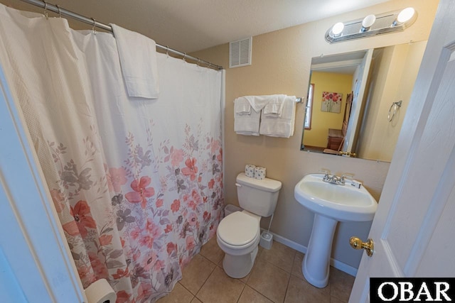 full bathroom with a sink, curtained shower, toilet, visible vents, and tile patterned flooring