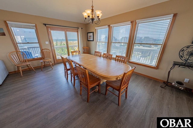 dining room with a notable chandelier, wood finished floors, and baseboards