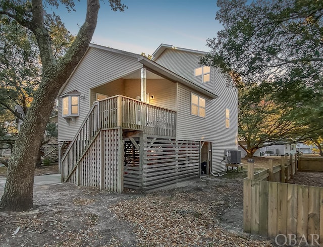 exterior space featuring fence, stairway, a deck, and central AC