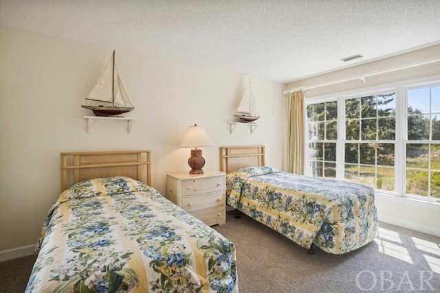 carpeted bedroom featuring visible vents, a textured ceiling, and baseboards