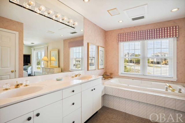 full bathroom with visible vents, a sink, a garden tub, and double vanity