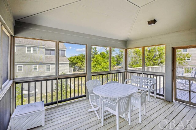 sunroom / solarium featuring vaulted ceiling