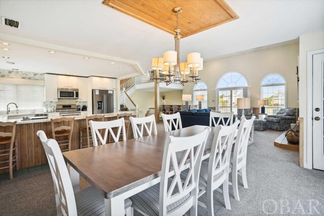 carpeted dining room featuring an inviting chandelier, stairs, visible vents, and recessed lighting