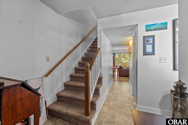 33 Croatan Ct Unit 33, Manteo, NC 27954 - stairway with baseboards, brick floor, and a textured ceiling