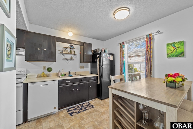 33 Croatan Ct Unit 33, Manteo, NC 27954 - kitchen with white appliances, light countertops, a textured ceiling, under cabinet range hood, and a sink