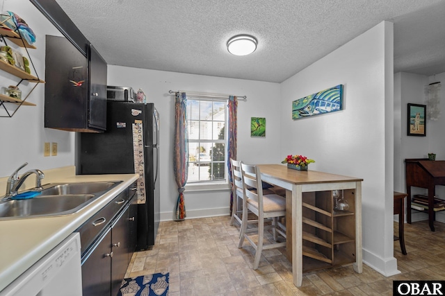 33 Croatan Ct Unit 33, Manteo, NC 27954 - kitchen featuring baseboards, light countertops, a textured ceiling, dishwasher, and a sink