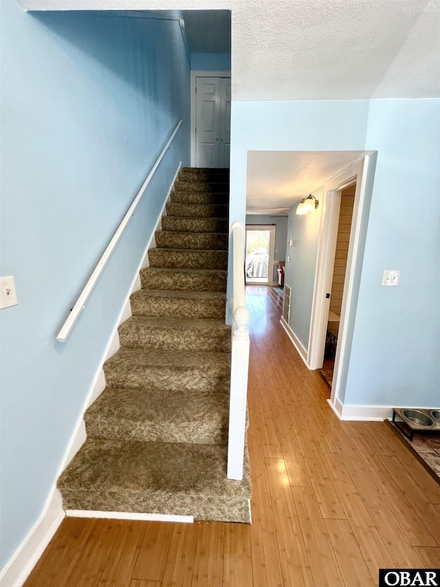 stairway featuring baseboards and wood finished floors