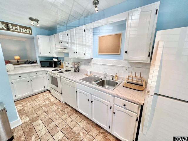 kitchen featuring white appliances, light countertops, white cabinetry, under cabinet range hood, and a sink