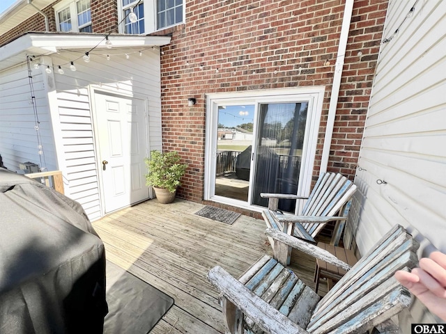 wooden terrace featuring a grill