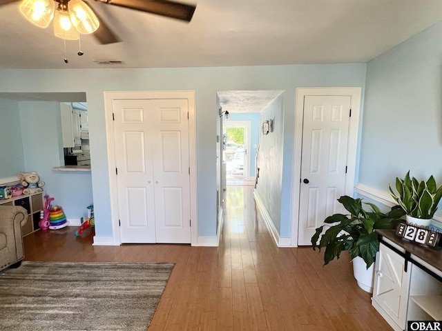 interior space featuring visible vents, baseboards, ceiling fan, and wood finished floors
