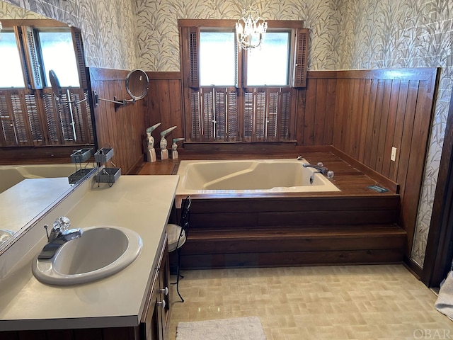 full bath featuring a wainscoted wall, a garden tub, vanity, and wallpapered walls