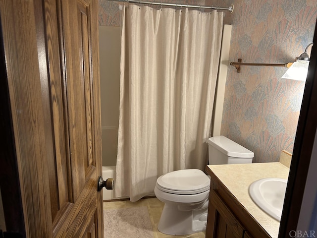 bathroom featuring toilet, shower / bathtub combination with curtain, vanity, and wallpapered walls