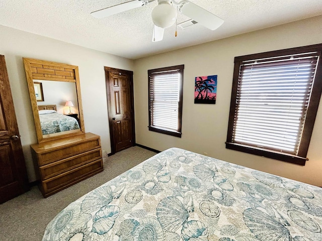 bedroom featuring light carpet, ceiling fan, visible vents, and a textured ceiling