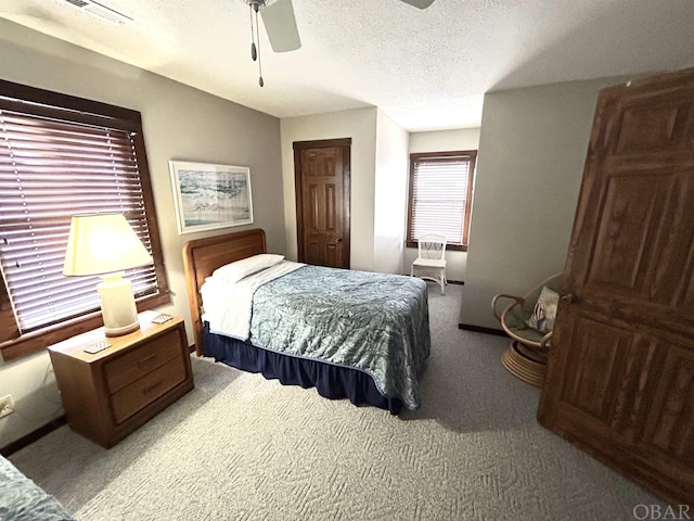 bedroom featuring carpet floors, a closet, visible vents, ceiling fan, and a textured ceiling