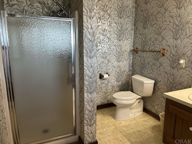 bathroom with wallpapered walls, baseboards, toilet, vanity, and a shower stall