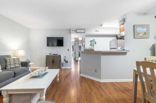 living room with dark wood-style floors, baseboards, and visible vents