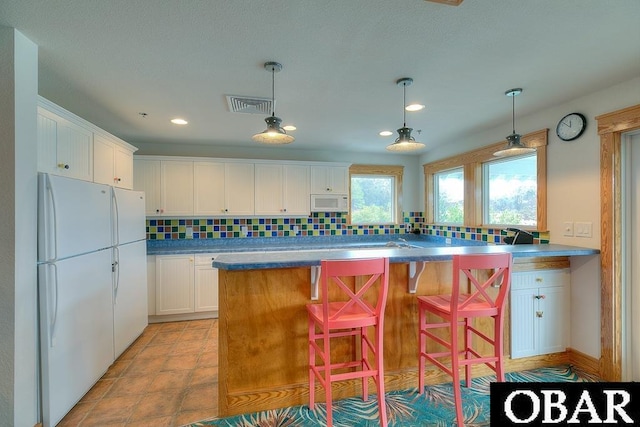 1800 Saint David Rd Unit 104-D 2, Kill Devil Hills, NC 27948 - kitchen featuring white appliances, tasteful backsplash, white cabinetry, pendant lighting, and recessed lighting